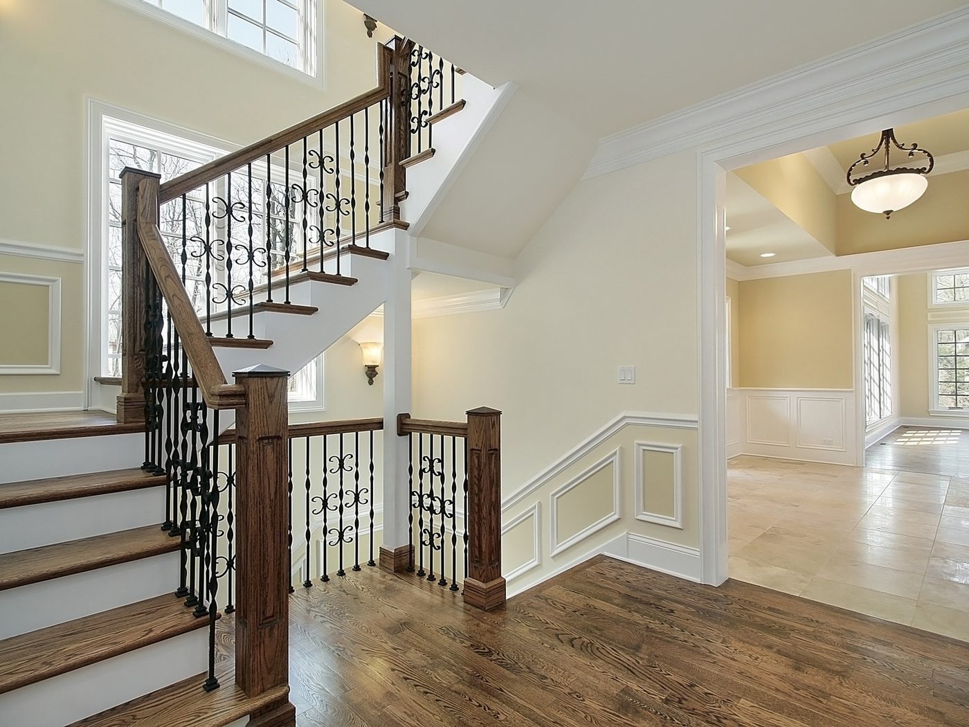 A curved staircase with wood treads and iron spindles, matched to the floor it opens onto